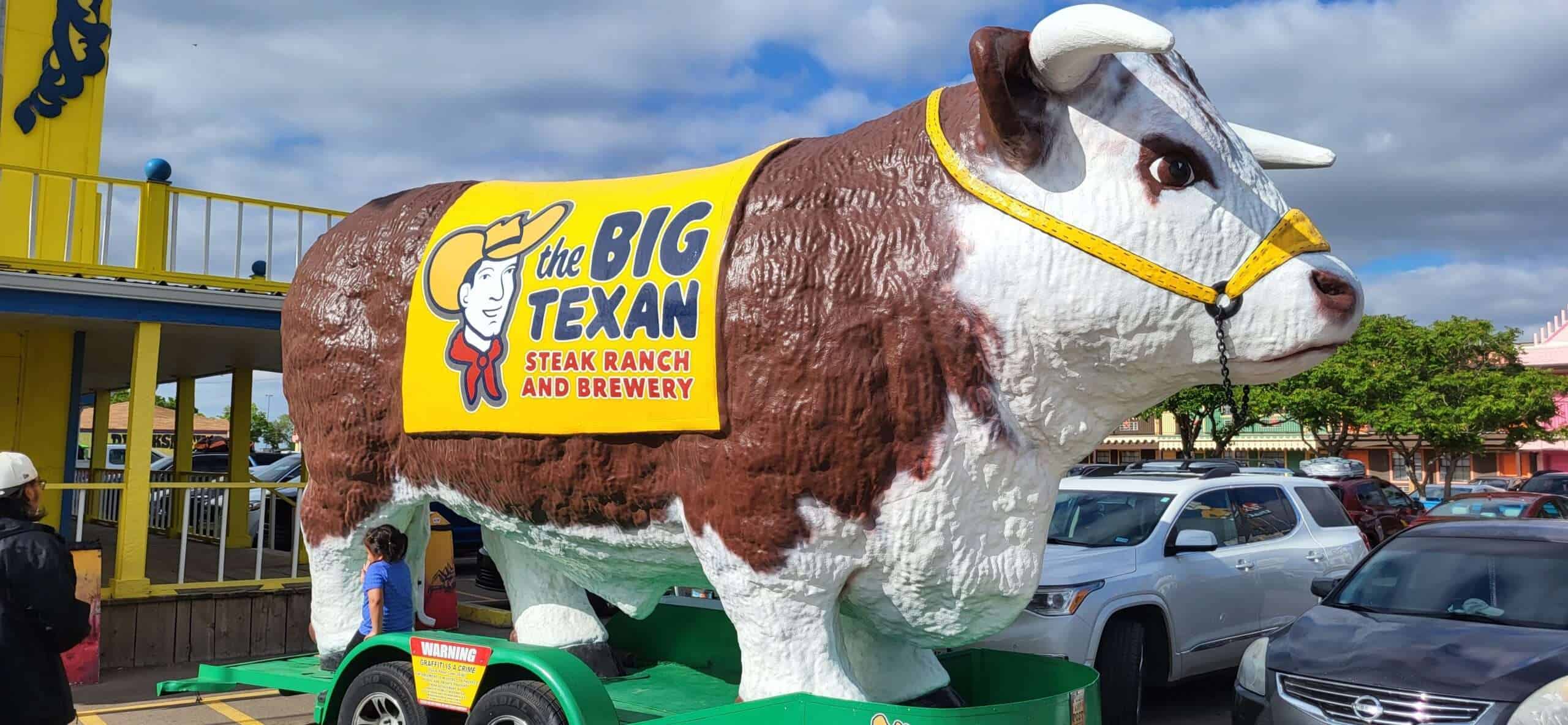 Amarillo Big Texan Rinder-Statue vor dem Steak Ranch und Brauerei in Texas, Touristenattraktion mit großem Rindermotiv, beliebtes Reiseziel für Steakliebhaber und Texanische Kultur.