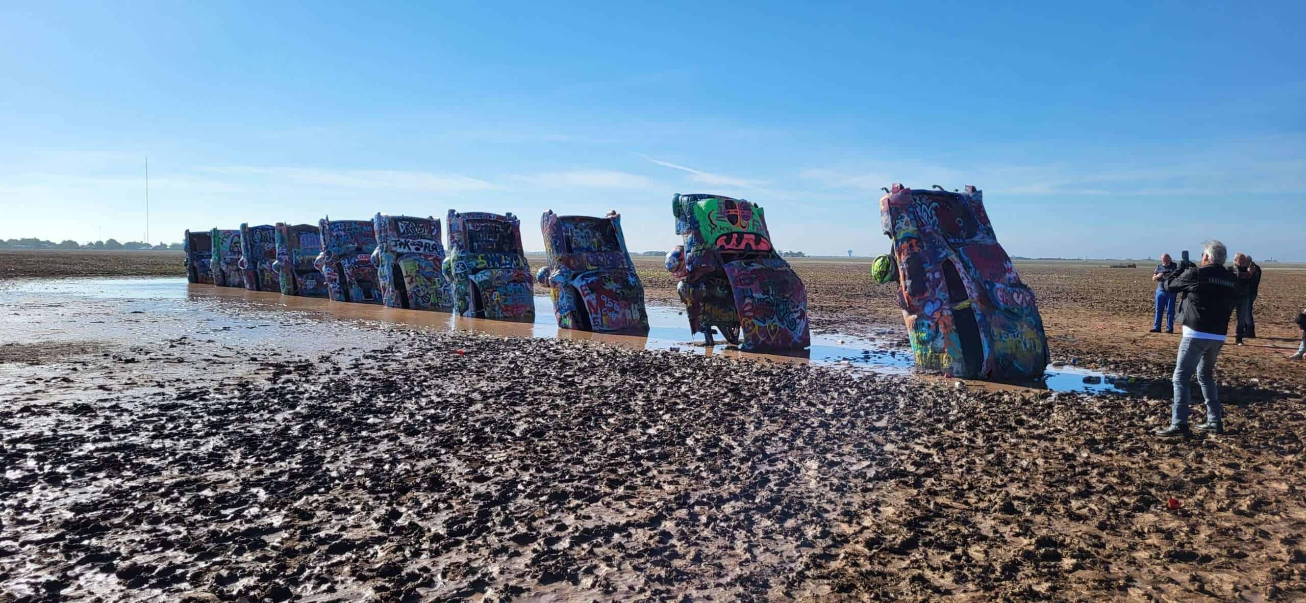 Cadillac Ranch Bunt bemalte Volkswagen Käfer auf einem Watt oder Flachland in New Mexico, USA, Kunstinstallation im Freien, mit Fotografen und Betrachtern im Hintergrund.