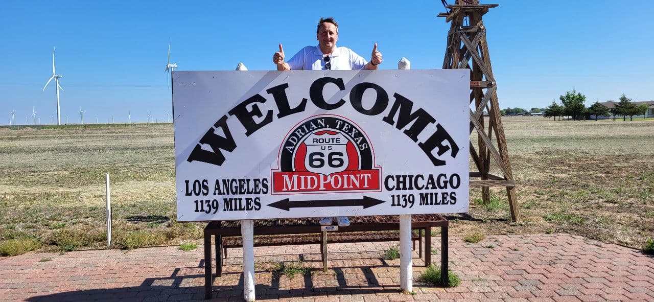 Route 66 Ein Schild mit einer Entfernungsangabe und dahinter ein Mann