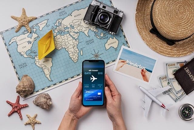 travel-app-development-9982596_640 Eine Landkarte, Photoapparat und Hände mit einem Handy