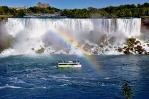 a boat in the water with a rainbow in the background