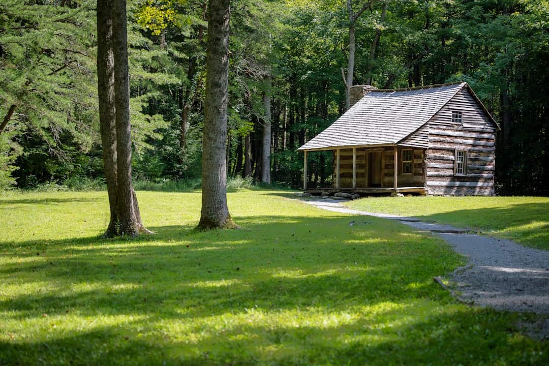 Photo by Delaney Van brown wooden house in the middle of green grass field