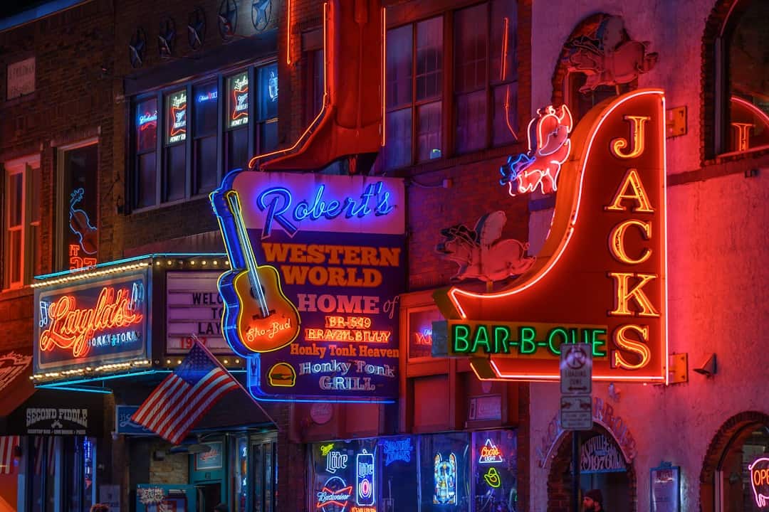Photo by Ricky Beron a city street filled with lots of neon signs