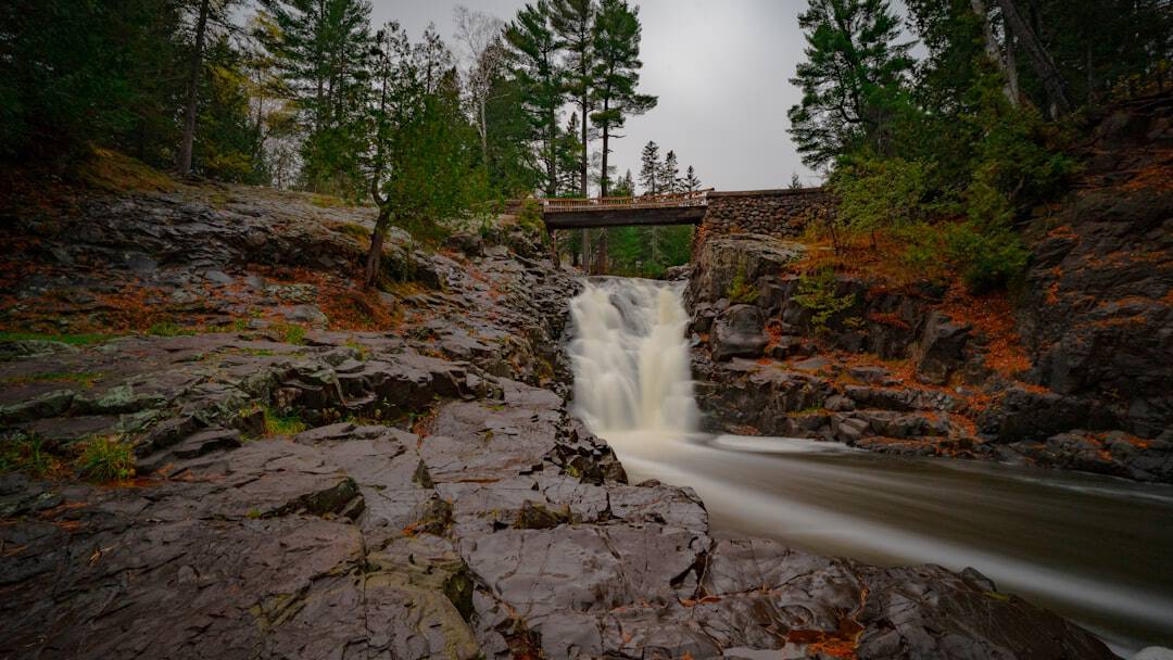 bridge above waterfalls during day