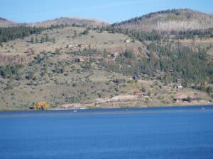 a large body of water surrounded by a lush green hillside