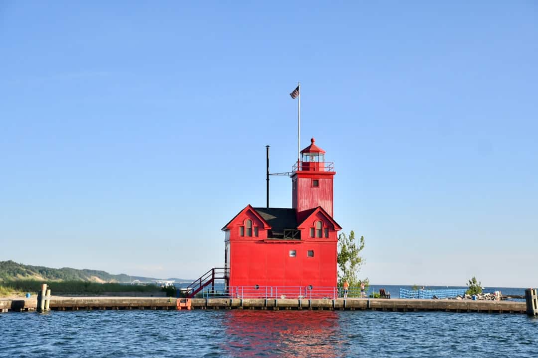 Photo by Peggy Paulson red concrete building with tower beside body of water