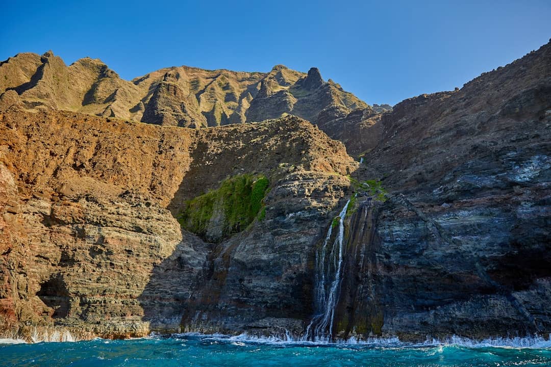 Waterfalls cascade down rocky cliffs.