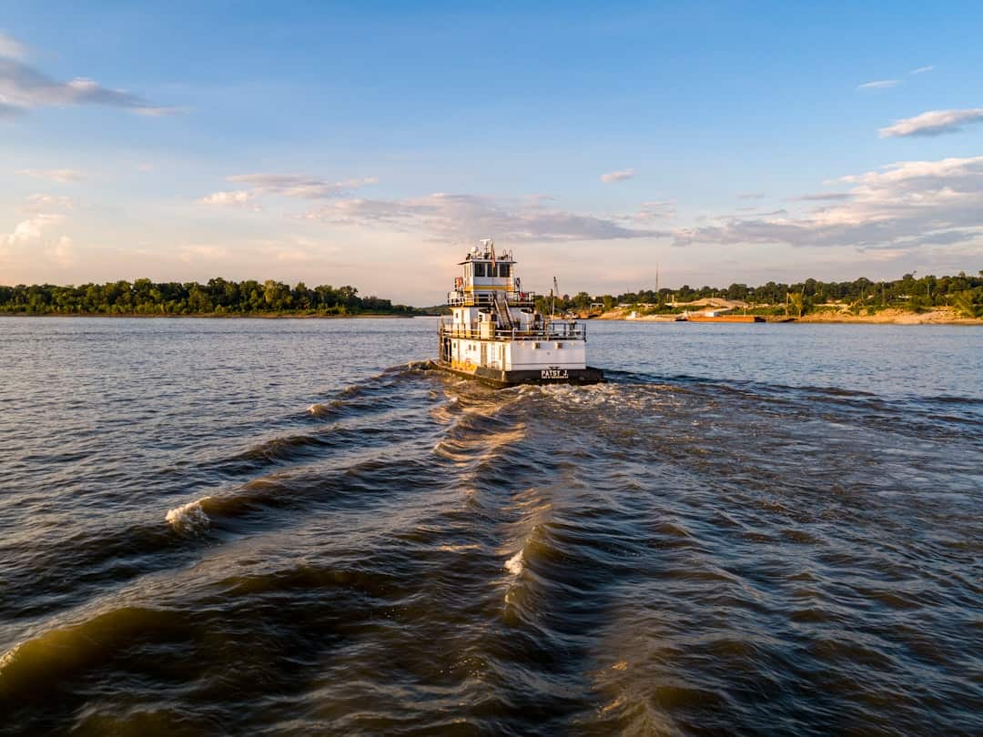Photo by Justin Wilkens white and brown concrete building on body of water under blue sky during daytime