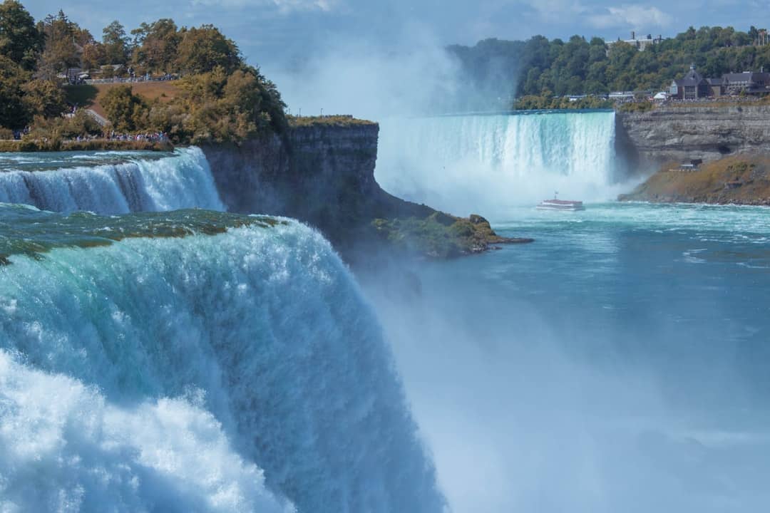 waterfalls near green trees during daytime