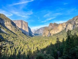 a scenic view of a valley with mountains in the background