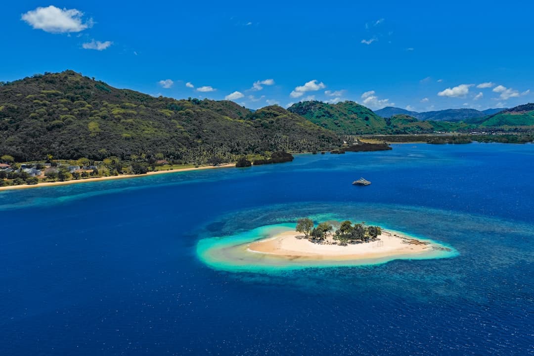 Photo by Tandya Rachmat blue lake surrounded by green mountains during daytime