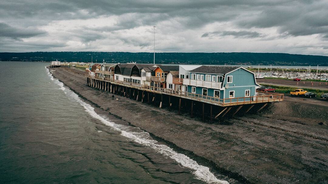 Photo by Corey Simoneau a pier with houses on top of it on a cloudy day