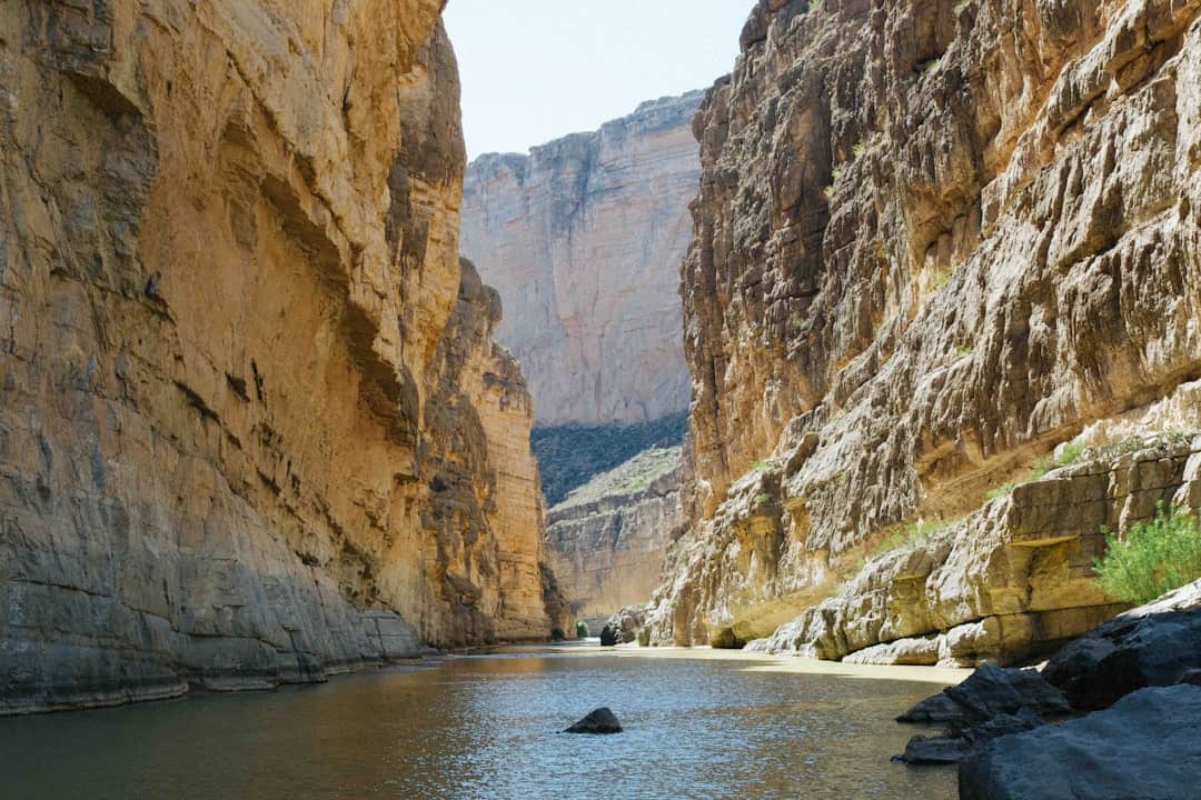 Photo by Kyle Glenn river between rocky mountains under clear sky